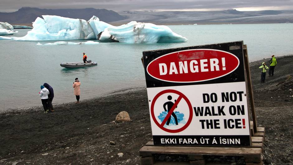 Im Süden Islands: Touristen machen an der Gletscherlagune Jökulsárlón Fotos vom See und den darin schwimmenden Eisbergen